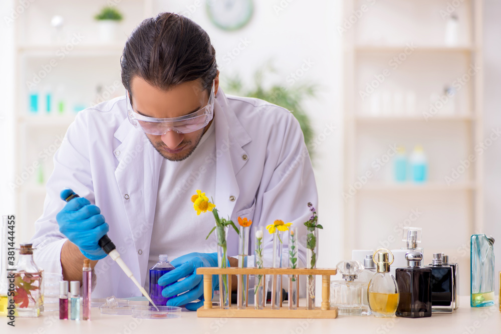 Young male chemist in perfume synthesis concept Young male chemist in perfume synthesis concept