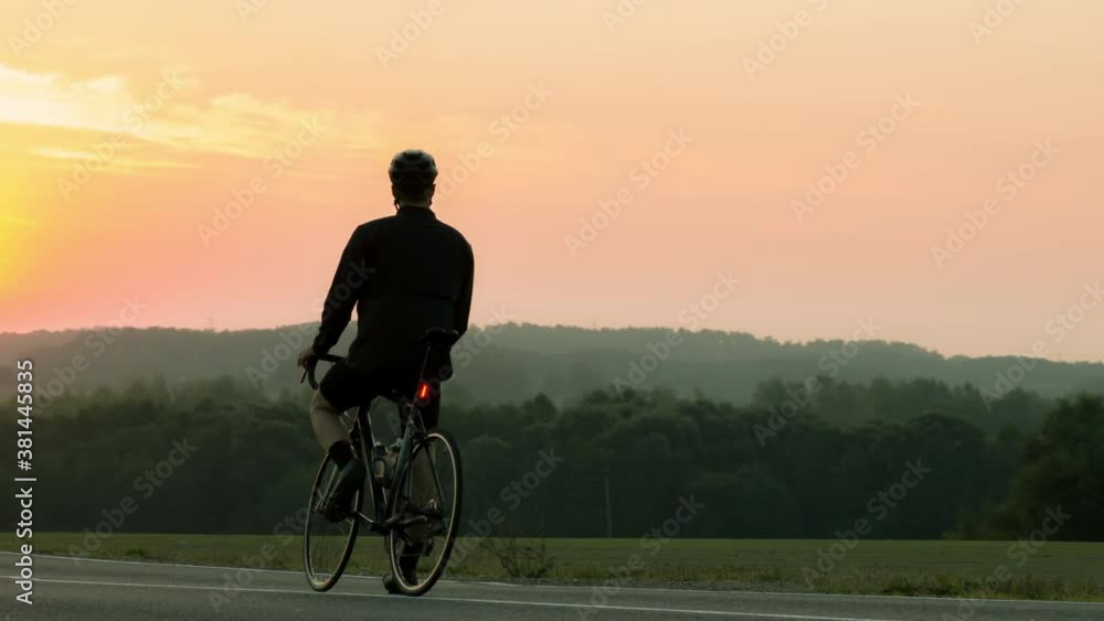 CU AERIAL DRONE SHOT Cyclist enjoys sunrise view during morning bicycle ride. Shot with telephoto lens CU AERIAL DRONE SHOT Cyclist enjoys sunrise view during morning bicycle ride. Shot with telephoto lens