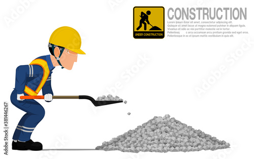 A construction worker is using shovel for scooping the crushed rock.