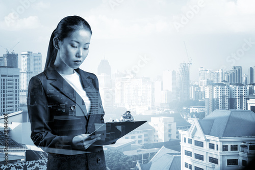 Photography Attractive young Asian business woman in suit taking notes into the notebook, new career opportunities, MBA assignment