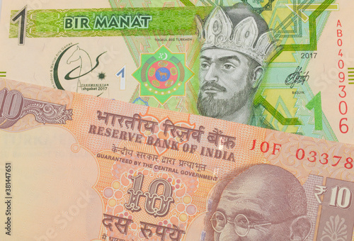 A macro image of a orange ten rupee bill from India paired up with a green and yellow one manat note from Turkmenistan.  Shot close up in macro.