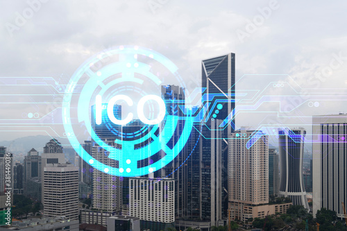 ICO icon hologram over panorama city view of Kuala Lumpur. KL is the hub of blockchain projects in Malaysia, Asia. The concept of initial coin offering. Double exposure.