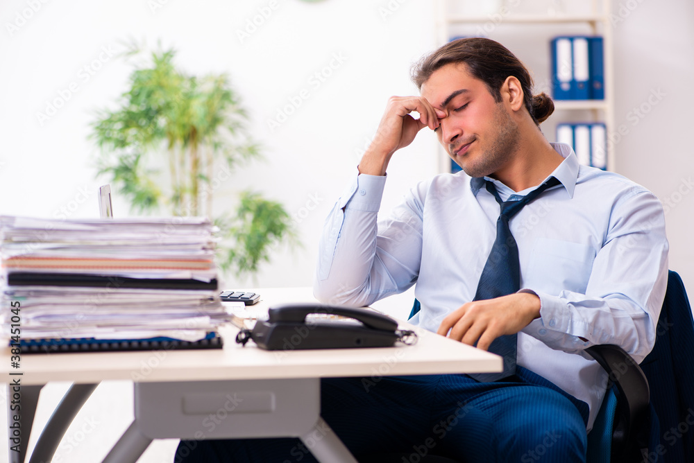 Obraz premium Young male employee unhappy with excessive work