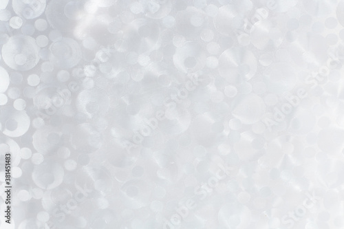 Background from transparent circles of different sizes in pearlescent color. Delicate texture.