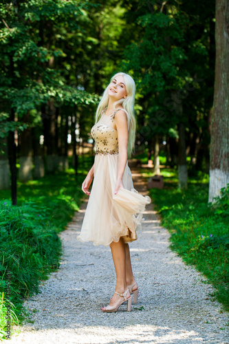 Young beautiful blonde girl in beige dress, summer park outdoor © Andrey_Arkusha