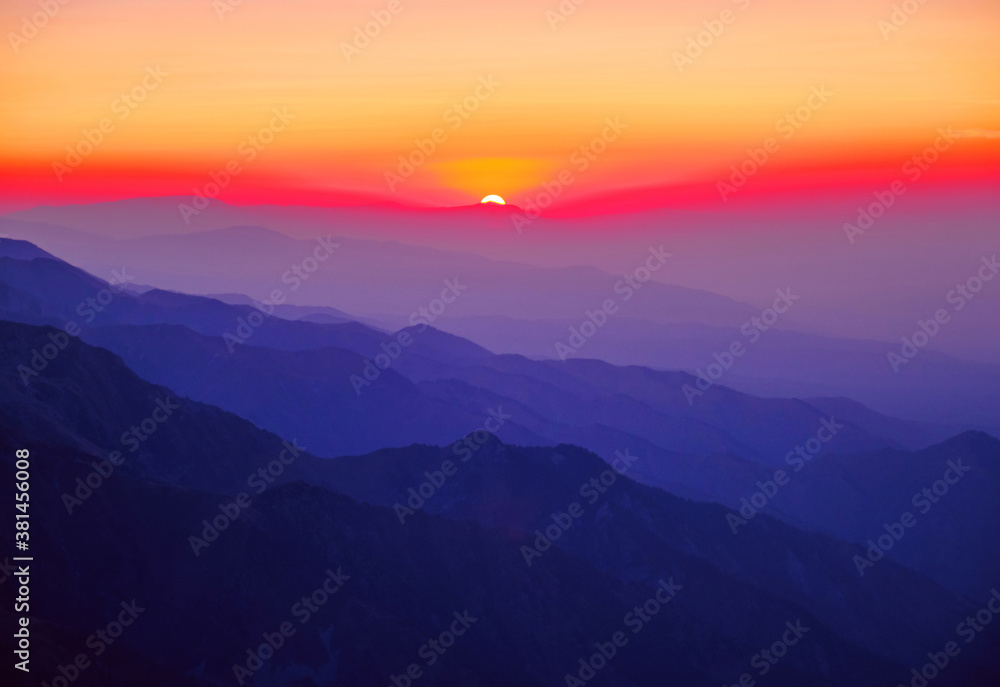 Majestic mountain landscape with silhouettes of mountain ridges at sunset