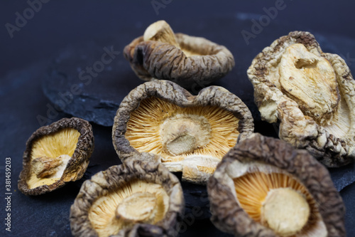 Macro closeup of isolated dried chinese shiitake mushrooms on slate stone background (focus on central mushroom)