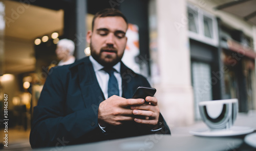 Blurred businessman using cellphone application for making online booking and banking,corporate director checking news of financial trade exchange on smartphone stock website connected to 4g on mobile