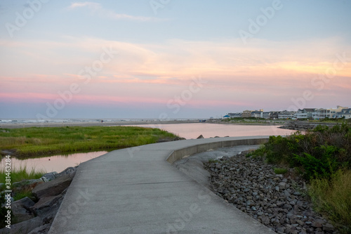 A Concrete Path With an Orange and Blue Sunset Sky Behind It at the North Wildwood Sea Wall in New Jersey