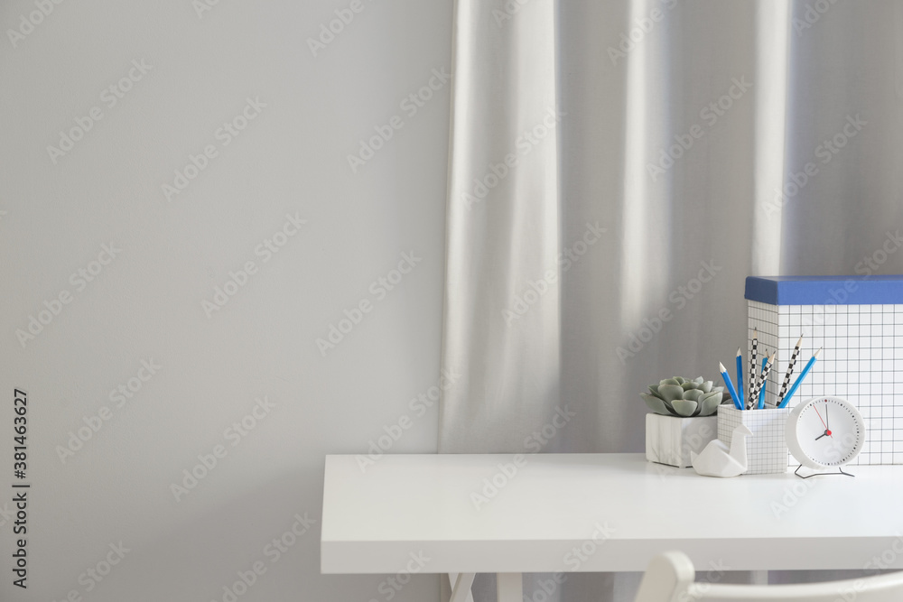 Desk at home office with desk objects, office supplies, books, and plant on a white background and wall copy space. Desk at home office with desk objects, office supplies, books, and plant on a white background and wall copy space.