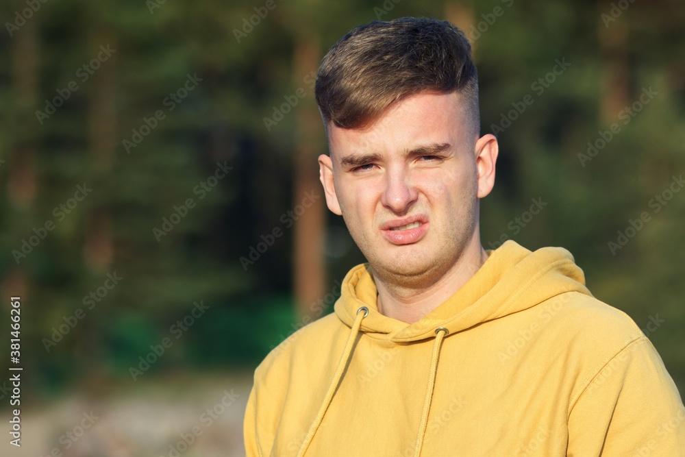Portrait of young frustrated man with disgusted face looking at camera outdoors and wrinkle Portrait of young frustrated man with disgusted face looking at camera outdoors and wrinkle