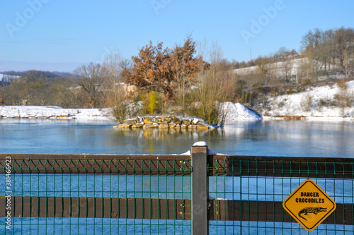 Lac view from village house. Snowy Winter rustic landscape in January. Funny inscription on the board