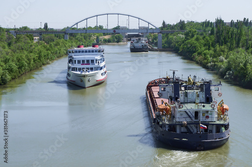 Papier peint A cruise ship with tourists passes through the Volga-Don Shipping Canal named after Lenin and diverges from cargo ships