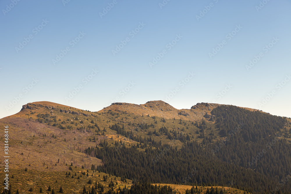 Impressive pointy peak called Tri Cuke on Balkan mountains (Stara planina) in Serbia, lighten by golden light and covered by pine tree forests Impressive pointy peak called Tri Cuke on Balkan mountains (Stara planina) in Serbia, lighten by golden light and covered by pine tree forests