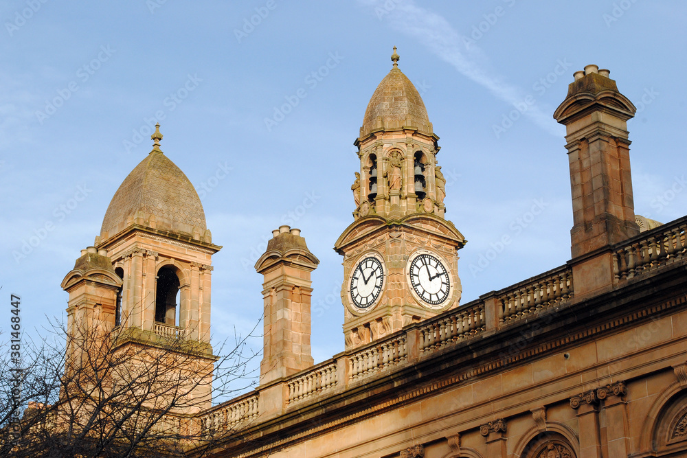 Stone Towers & Clock on Old Stone Public Building against Blue Sky Stone Towers & Clock on Old Stone Public Building against Blue Sky