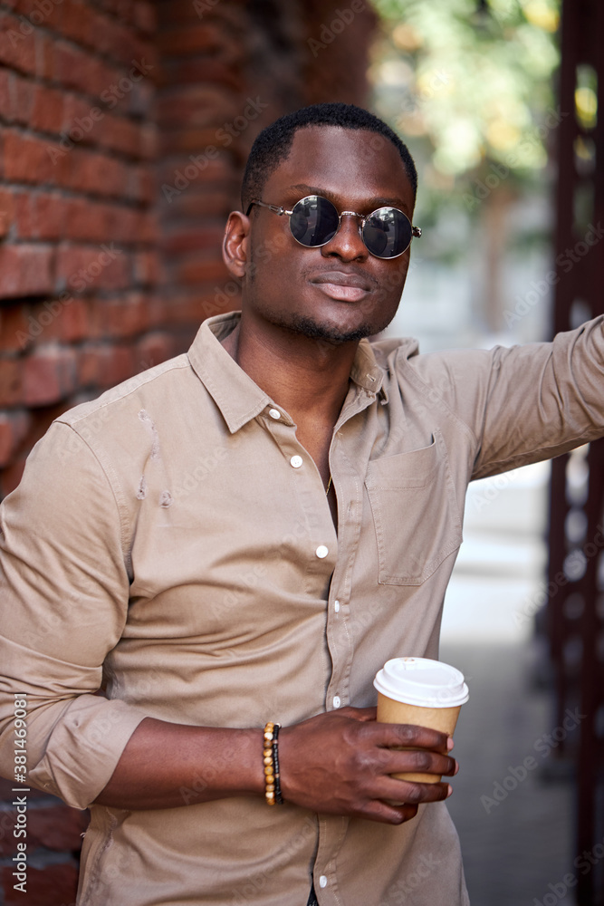 good-looking afro american man have rest outdoors, drink coffee, walk after work. leisure time in city good-looking afro american man have rest outdoors, drink coffee, walk after work. leisure time in city