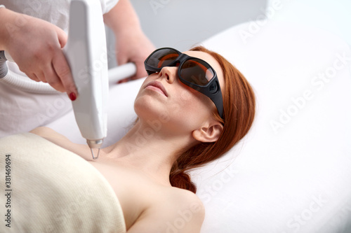 skin and body care. woman receives an electric massage in beauty salon, pleased woman take care of skin, came to get healthy and soft body