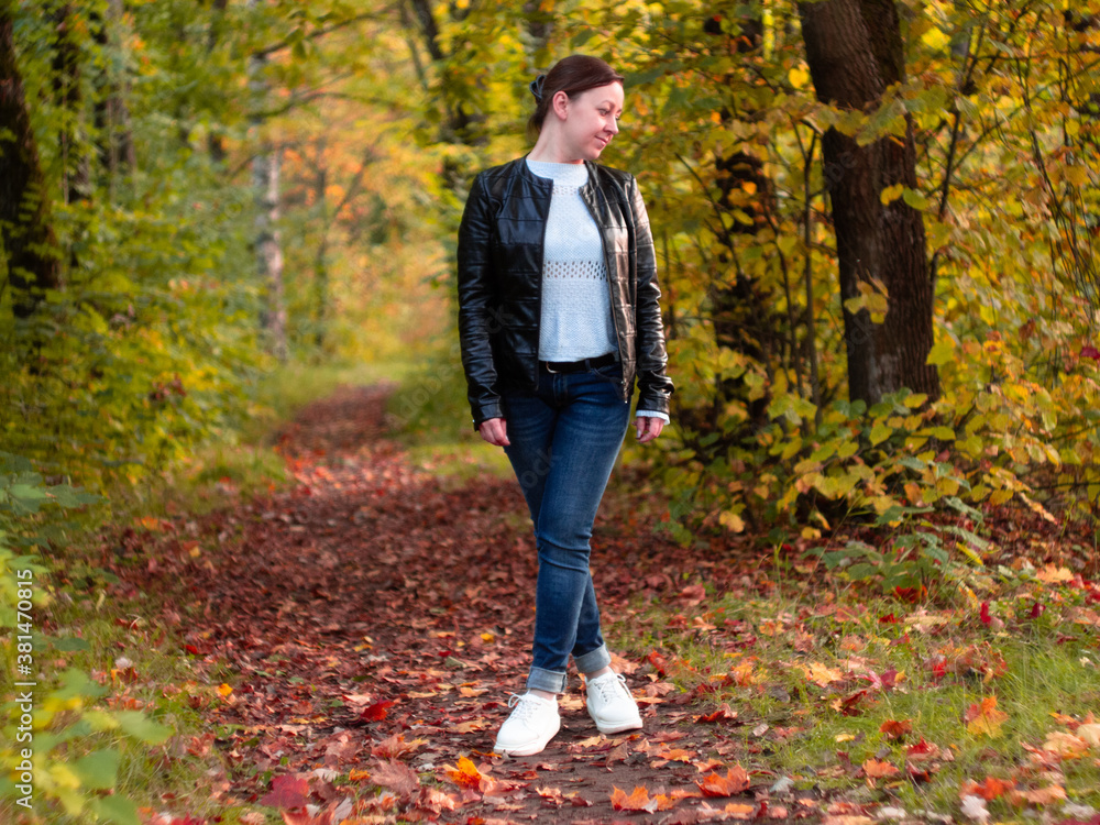 cute woman in leather jacket in autumn Park. beautiful Park alley. bright colors of autumn