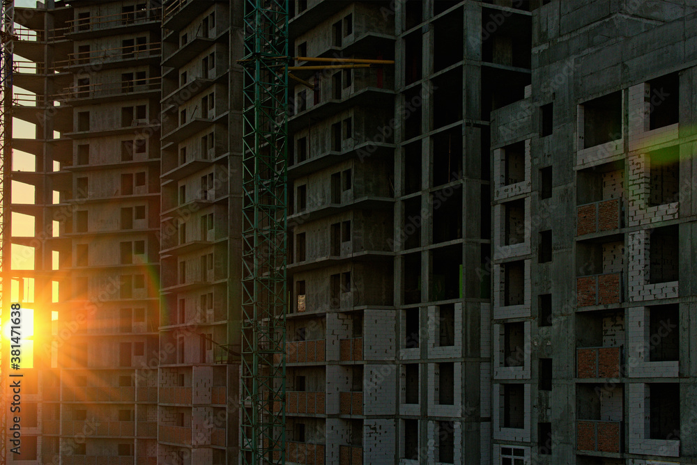 Sun shine through the concrete construction of new multi-storey building. Autumn sunrise in the construction site. Abstract glitter light effect star beam sun. Kyiv, Ukraine Sun shine through the concrete construction of new multi-storey building. Autumn sunrise in the construction site. Abstract glitter light effect star beam sun. Kyiv, Ukraine