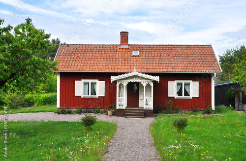 Fototapeta Typical idyllic red cottage in Sweden