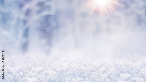 Winter abstract Christmas background with snow in the forest and sunbeams