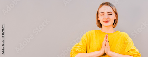 Namaste peace your house. Relaxed peaceful charming friendly european girl press palms together buddhism gesture smiling cute thanking dear guest hold hands pray standing gray background photo