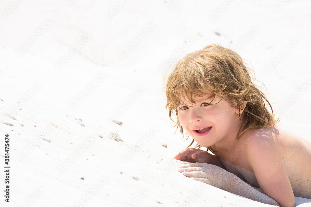 Happy child boy play with sand in the sea. Kid tan, suntan. Gentle kids skin tanning.