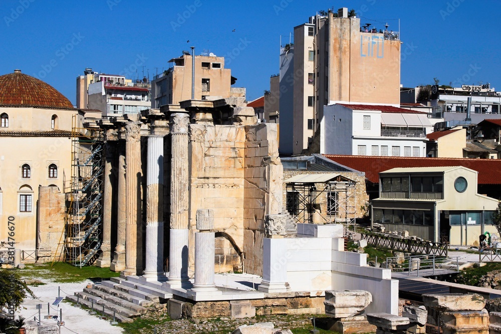 View of the archaeological site of the Hadrian's Library with an old mosque and modern buildings in the background - Athens, Greece, February 4 2020.