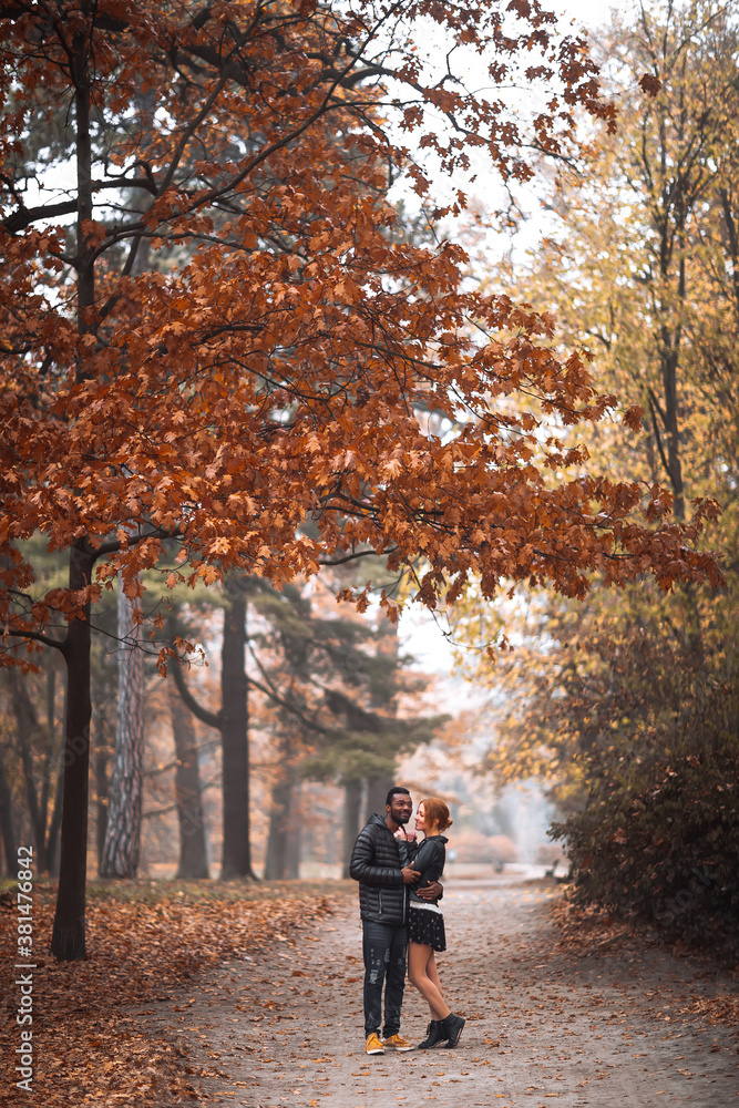 Happy interracial couple walking in autumn park