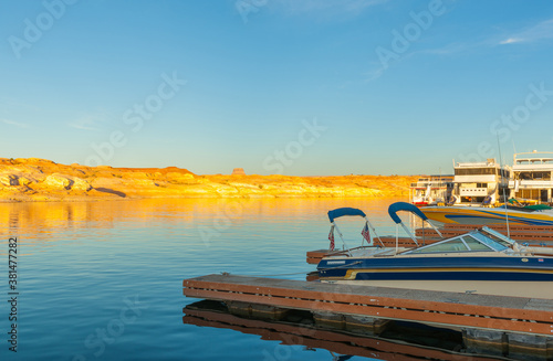 As sunsets light hits the rock embankments with a golden glow on other side Lake Powell a man-made reservoir on the Colorado River in Utah and Arizona