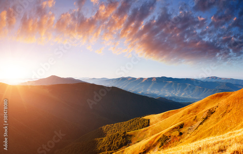 Picturesque sunset in the summer mountains. Evening light illuminates the valley.