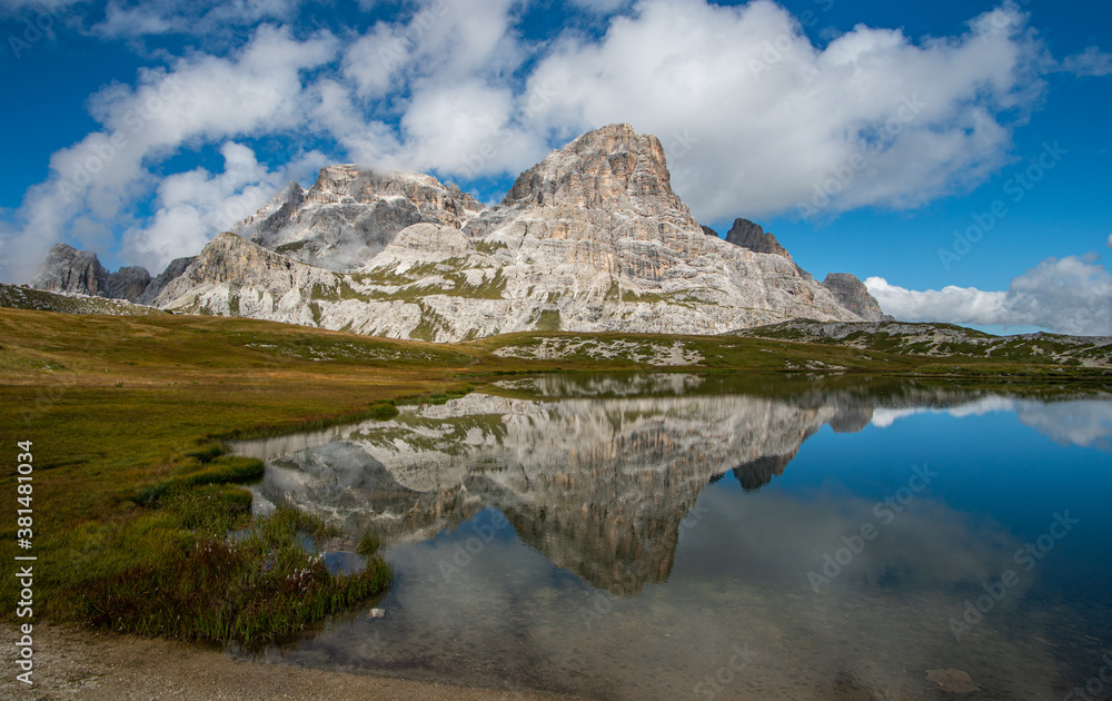 an alpine lake with the reflection of the mountains in the Dolomites in South Tyrol,  Italy