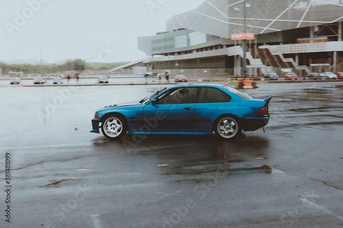 Cars are drifting in the old parking lot. Rain drift. Gray photo processing, atmosphere. Racing in the city.