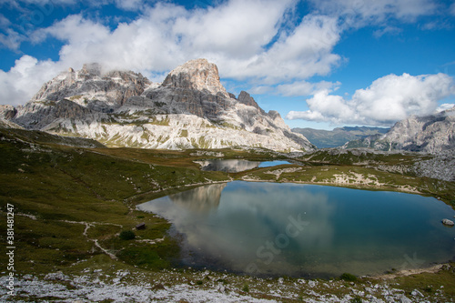 an alpine lake with the reflection of the mountains in the Dolomites in South Tyrol, Italy
