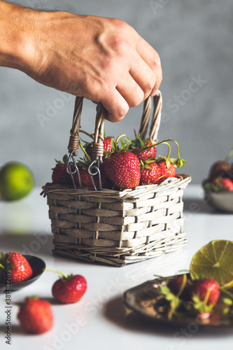 fresh strawberries in a basket on a white wooden table photo