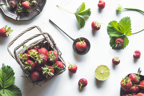 fresh strawberries in a basket on a white wooden table