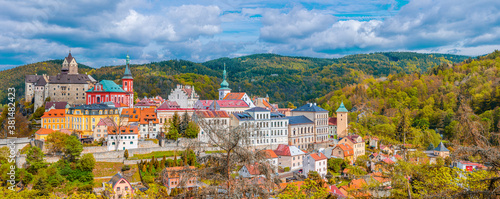 Aerial panoramic view of medieval Loket town with Loket Castle Hrad Loket gothic style on massive rock, colorful buildings. Panorama of Loket town and forest hills in autumn, Czech Republic
