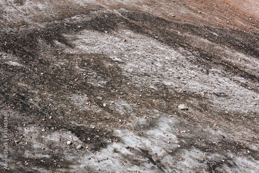 Naklejka premium surface of a melting mountain glacier covered with stones and rubble