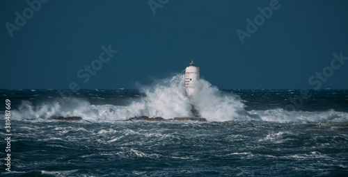 The lighthouse of the Mangiabarche shrouded by the waves of a mistral wind storm 