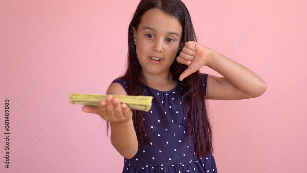 Cute little girl holding dollars, isolated over pink Cute little girl holding dollars, isolated over pink