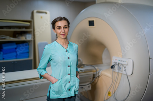 Radiologist is posing near CT or MRI machine. Professional and modern technic in hospital.
