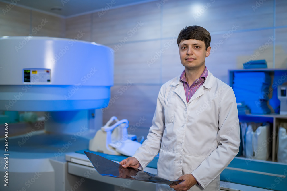 Medical CT or MRI or PET Scan standing in the modern hospital laboratory. Radiologist holding x-ray in hands. Medical CT or MRI or PET Scan standing in the modern hospital laboratory. Radiologist holding x-ray in hands.