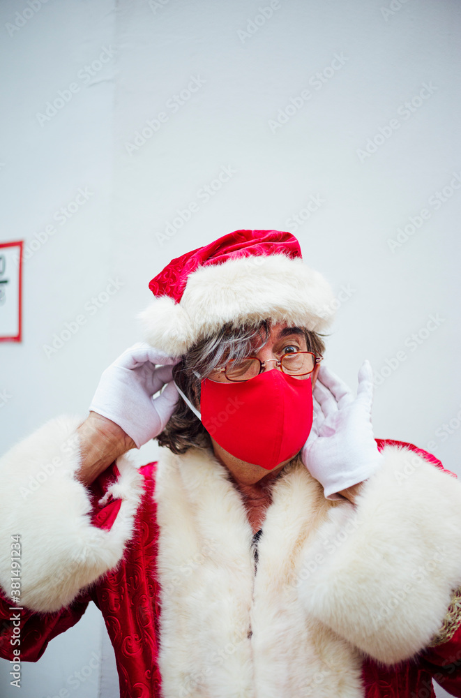 Santa Claus putting on a mask in the city of Madrid. Santa Claus putting on a mask in the city of Madrid.