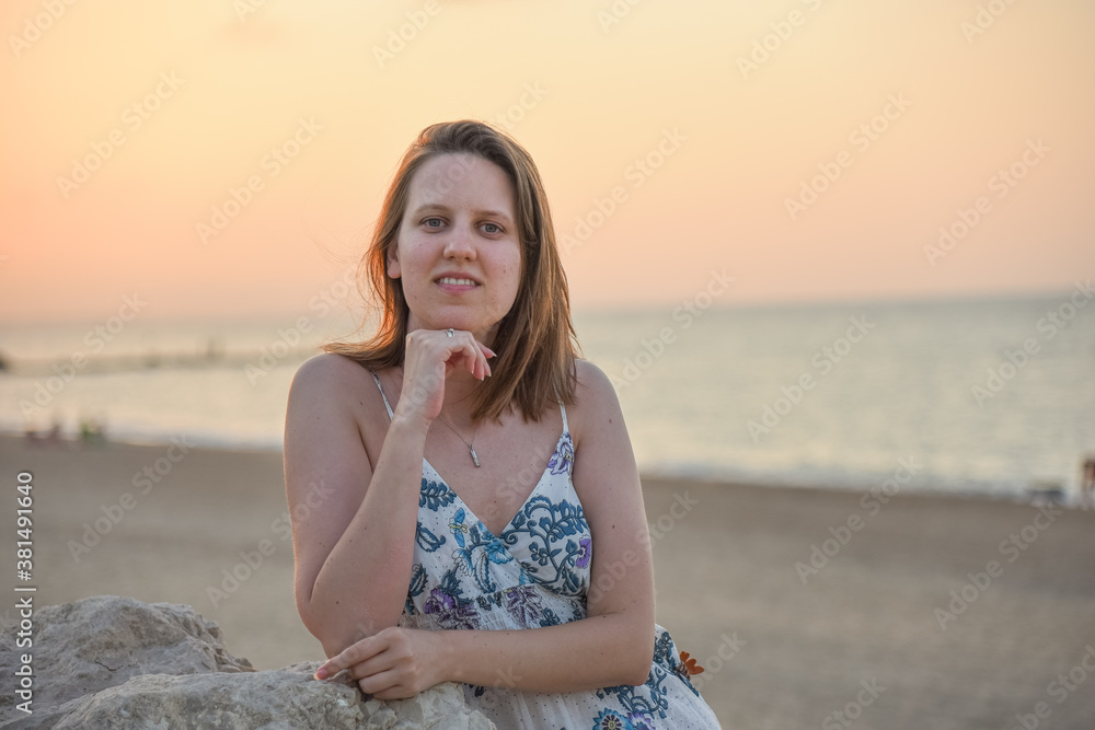 Mujer joven paseando en la playa a la puesta de sol Mujer joven paseando en la playa a la puesta de sol