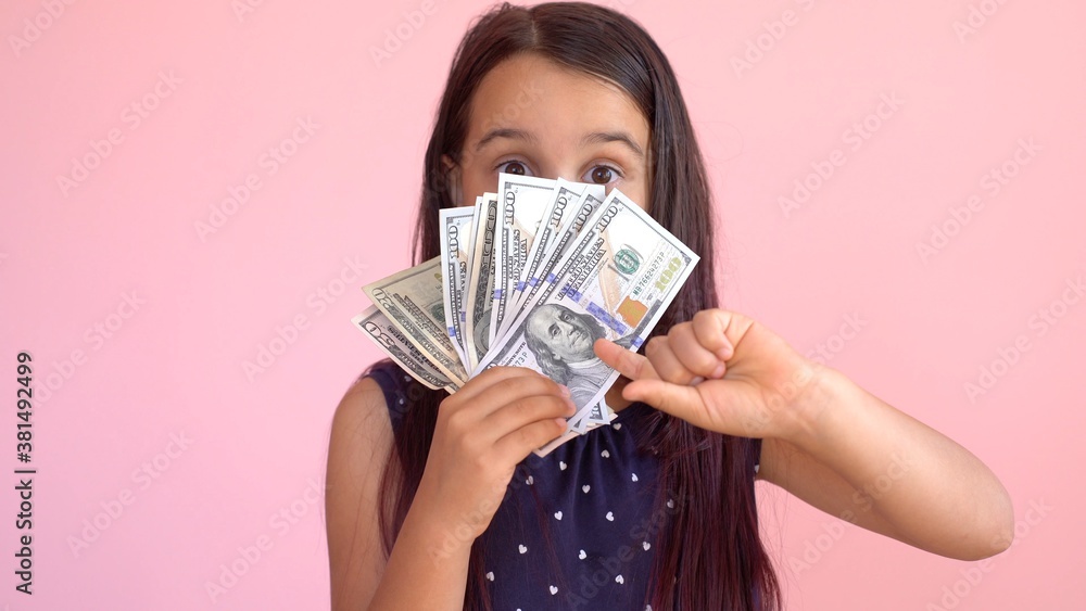 Cute little girl holding dollars, isolated over pink Cute little girl holding dollars, isolated over pink
