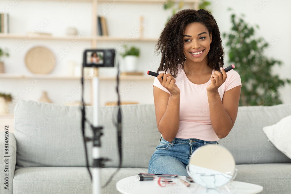 African American Female Beauty Blogger Reviewing Cosmetics Sitting At Home