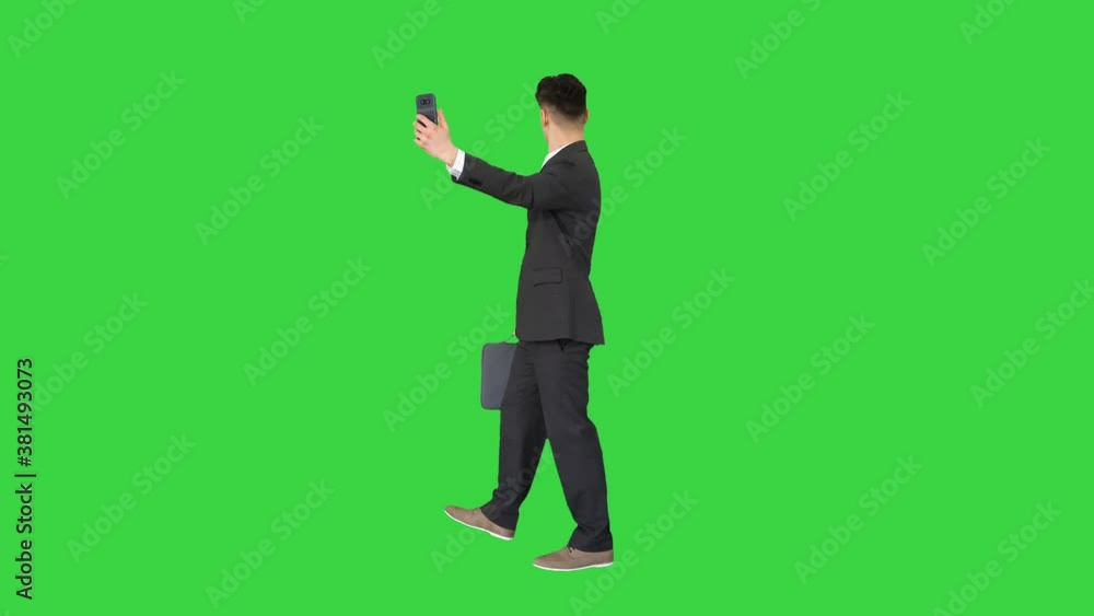 Young business man walking and taking a selfie on a Green Screen, Chroma Key. Young business man walking and taking a selfie on a Green Screen, Chroma Key.