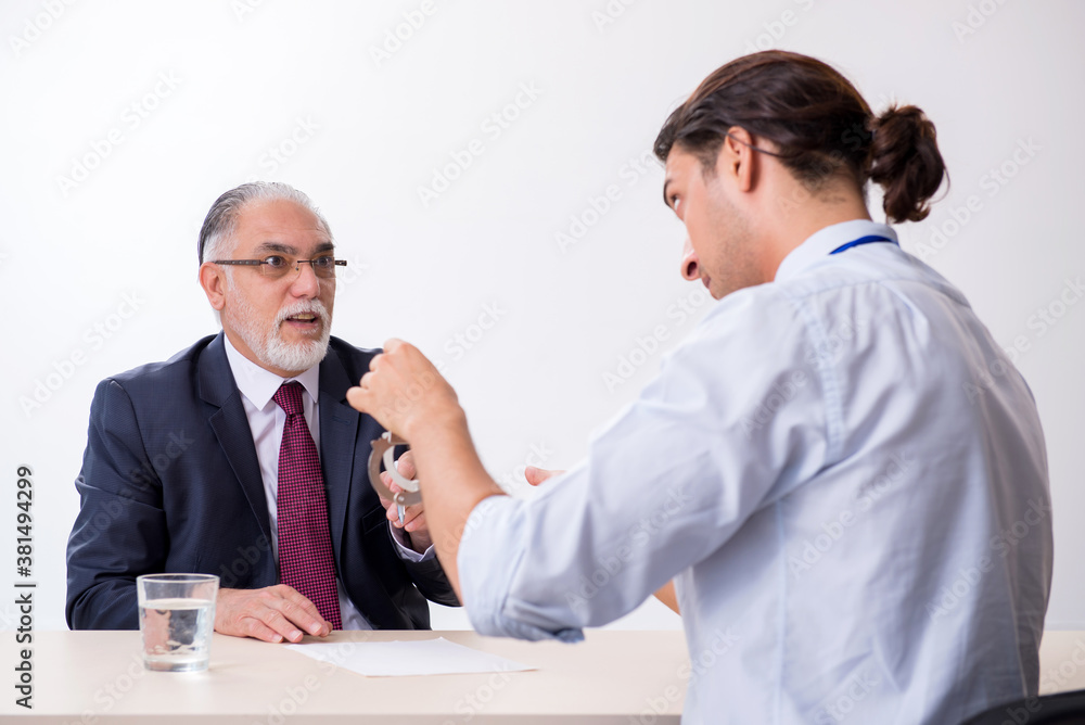 Old businessman meeting with advocate in pre-trial detention Old businessman meeting with advocate in pre-trial detention