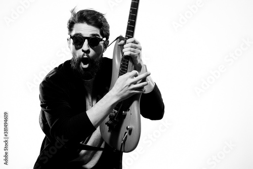 man with guitar in hands musician rock star performance lifestyle light background
