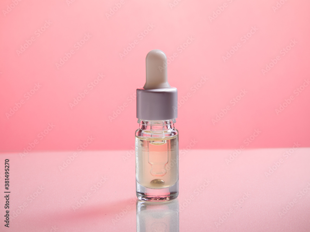 Amber glass bottles on pink background. Natural organic cosmetic packaging, luxury beauty products for body care. amber bottle for essential oils and cosmetics Amber glass bottles on pink background. Natural organic cosmetic packaging, luxury beauty products for body care. amber bottle for essential oils and cosmetics